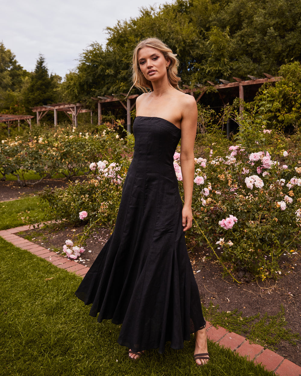 woman in park wearing black strapless dress 