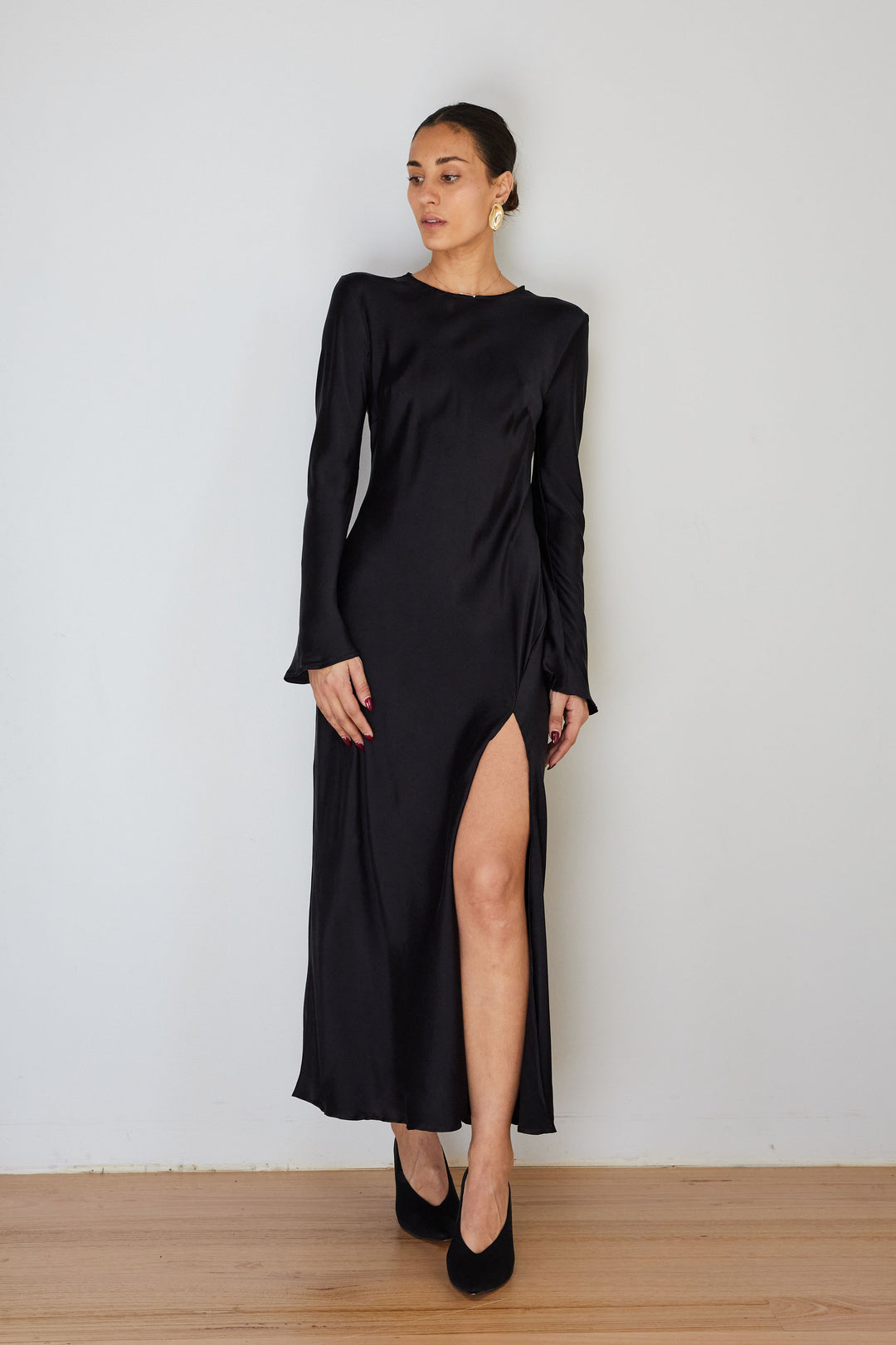Woman wearing long sleeve, black silk dress.