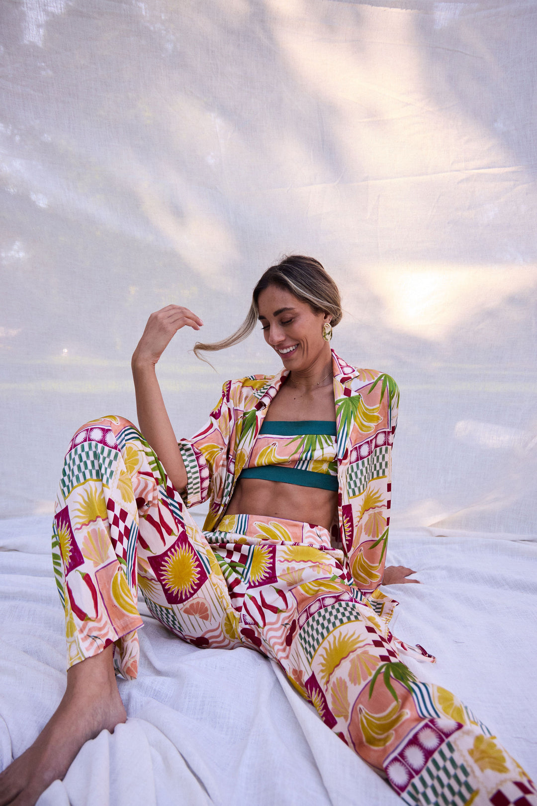 Woman in a colorful outfit sitting on a white surface with a blurred background