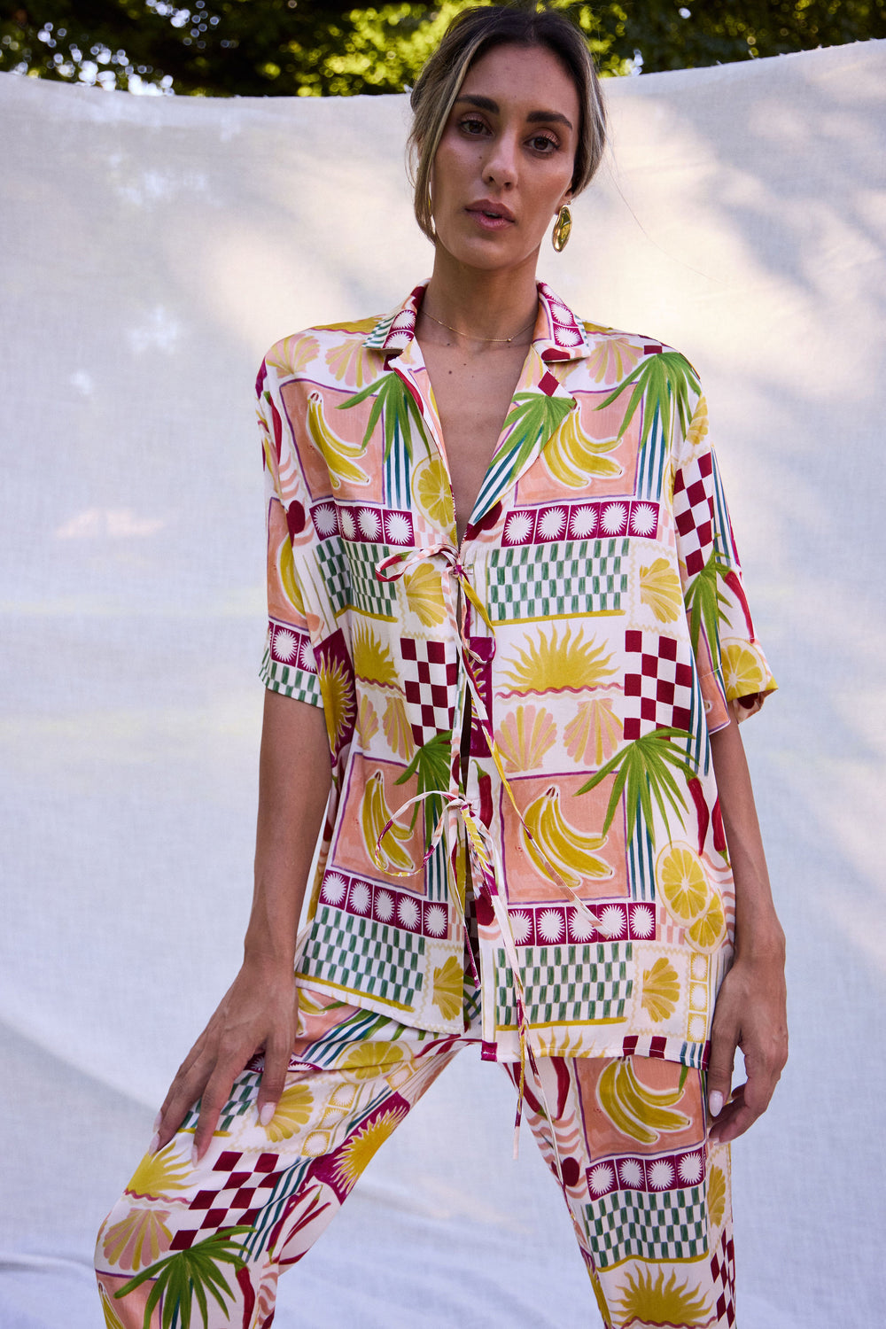 Woman wearing a colorful patterned outfit with a white background