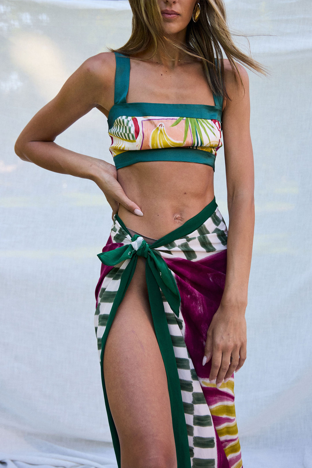 Woman wearing a colorful bikini with a matching sarong against a white background