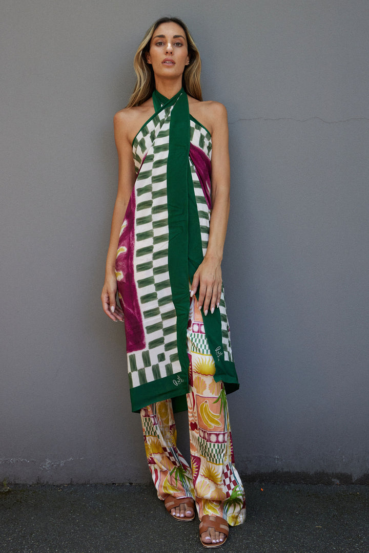 Woman wearing a colorful patterned dress against a gray background