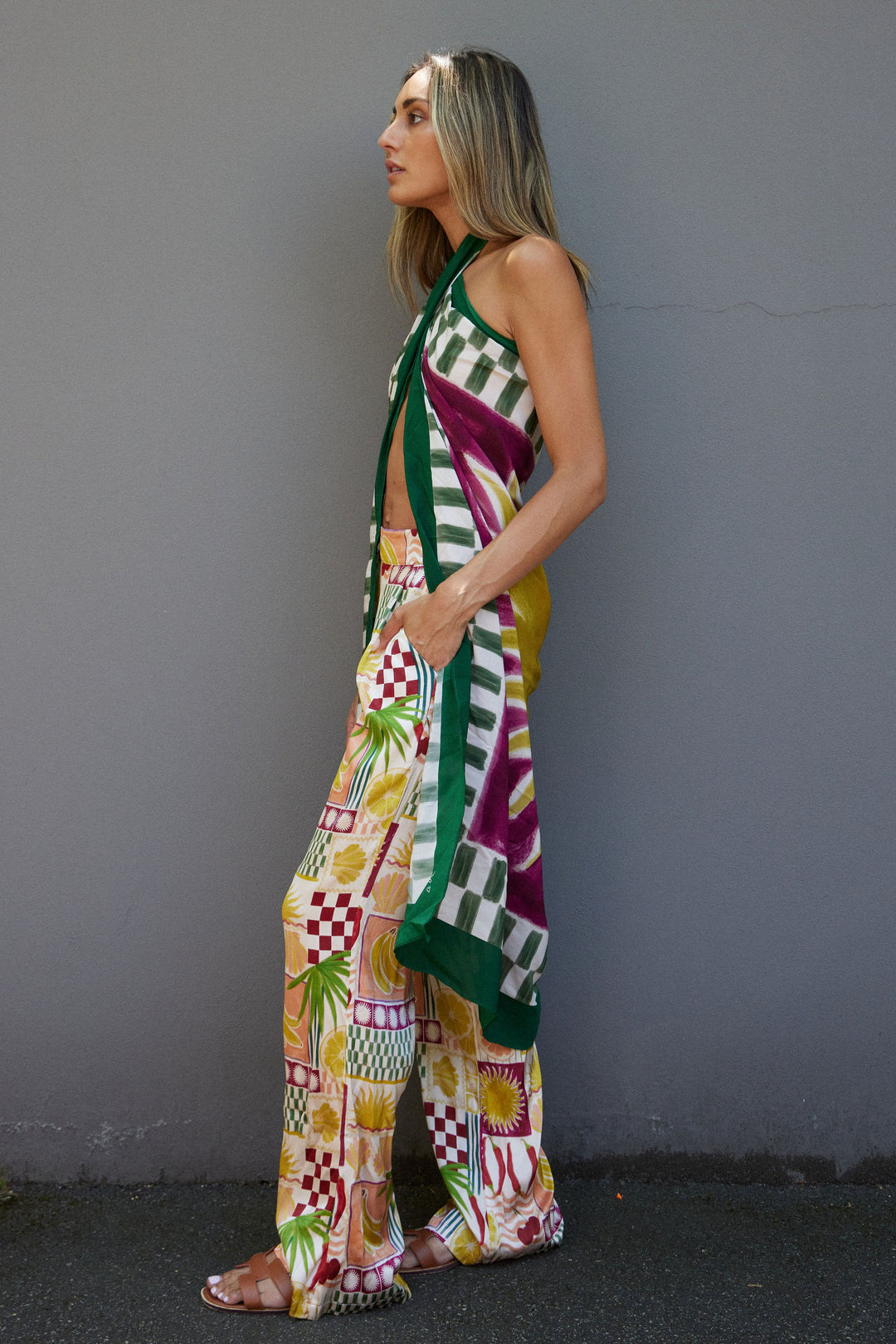 Woman wearing a colorful patterned outfit against a gray background