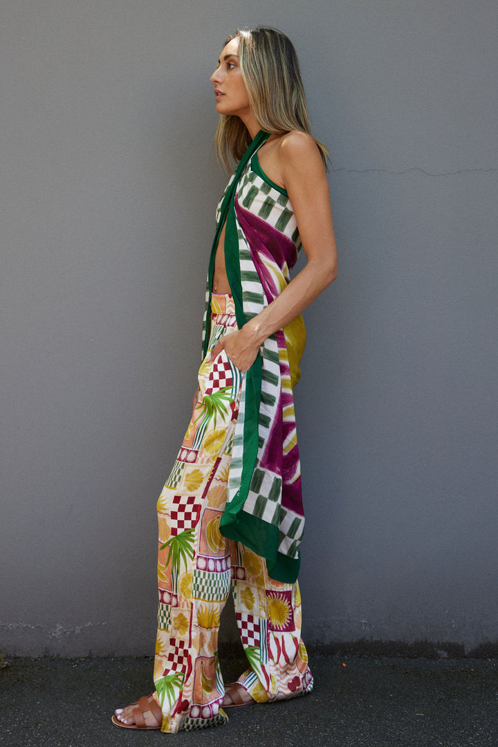 Woman wearing a colorful patterned outfit against a gray background