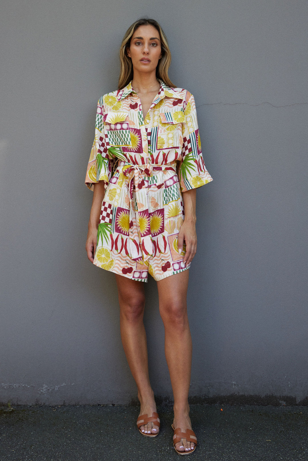 Woman wearing a colorful patterned dress against a plain background